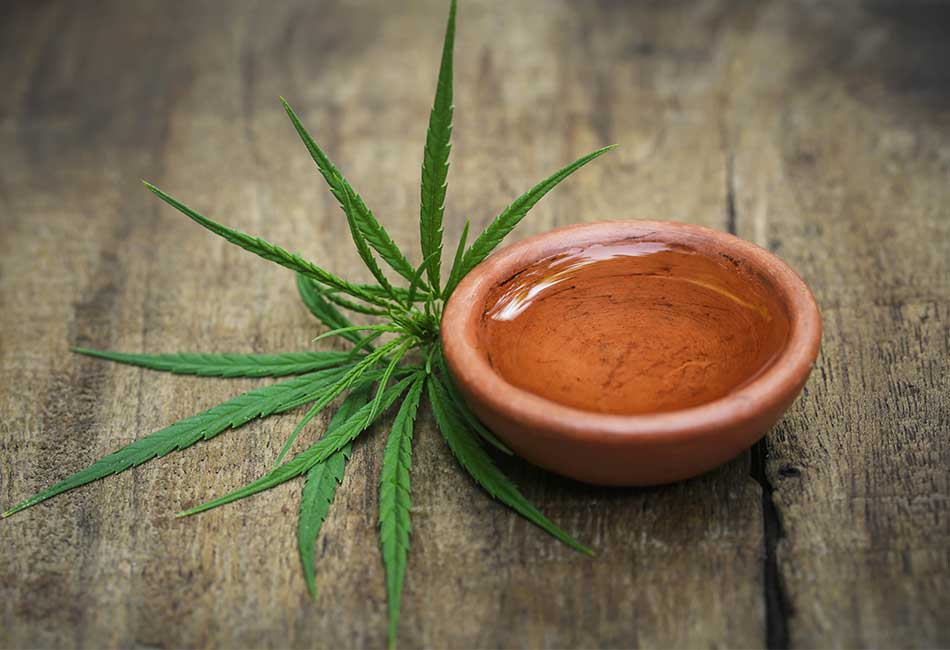 CA cannabis leaf and cannabis oil shown on a table for Flexible Pack